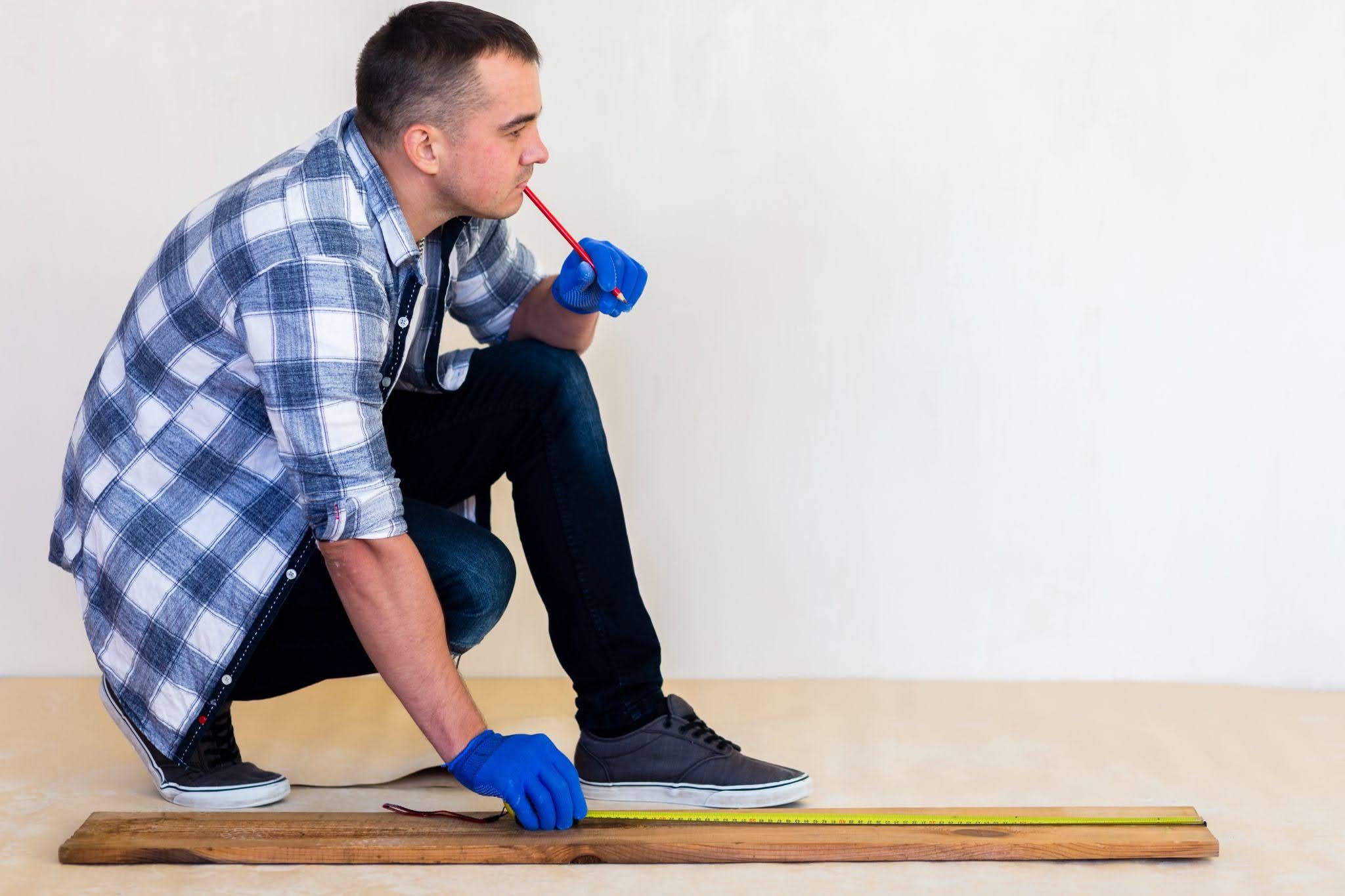 Floor inspector measuring hardwood flooring before installation.